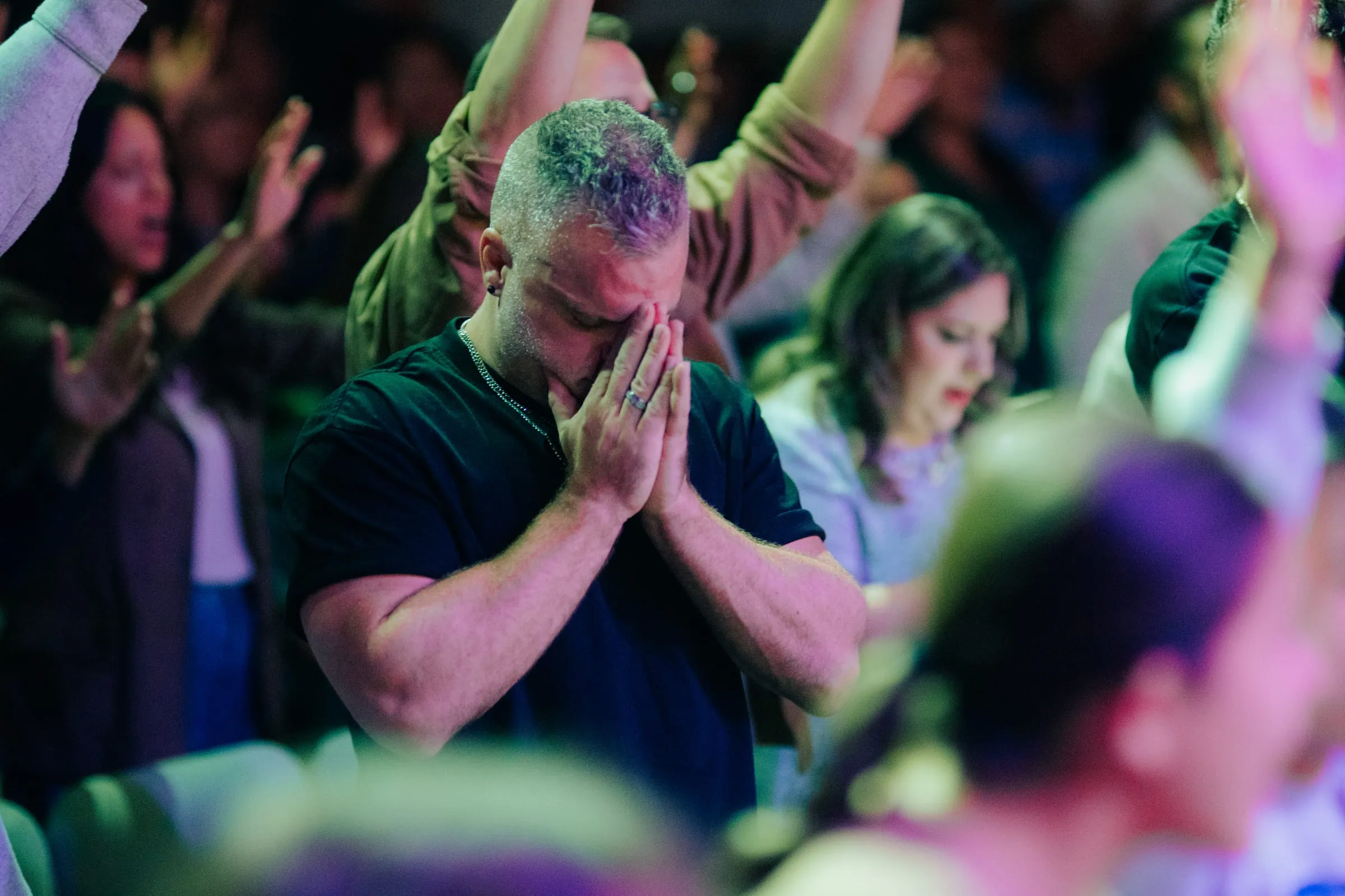 Shawn Gabie praying among a worshipping crowd
