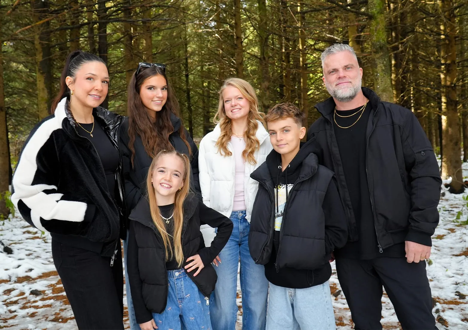 Shawn, Michelle and their four children standing together in a winter forest