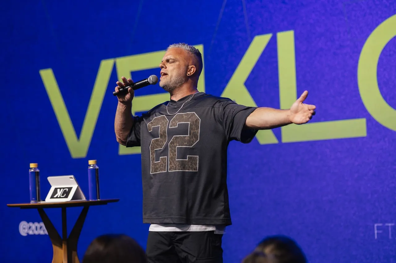 Shawn Gabie speaking with open arms to a large conference audience